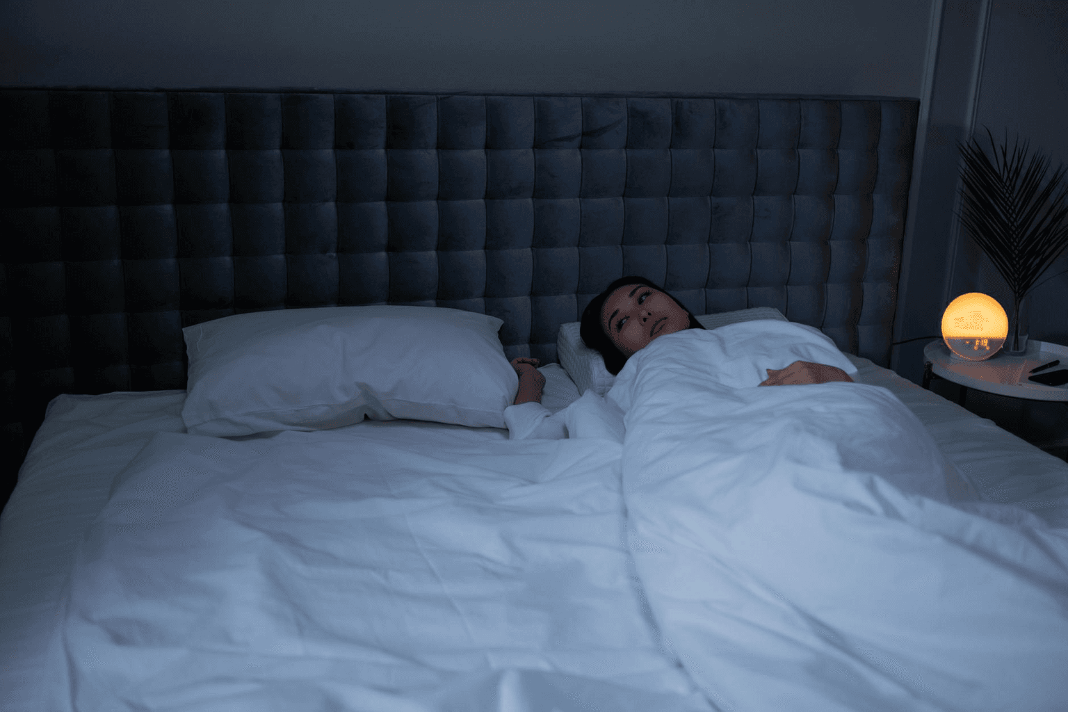 Peaceful bedroom at night with soft moonlight and a gentle golden glow representing restful sleep and subconscious programming