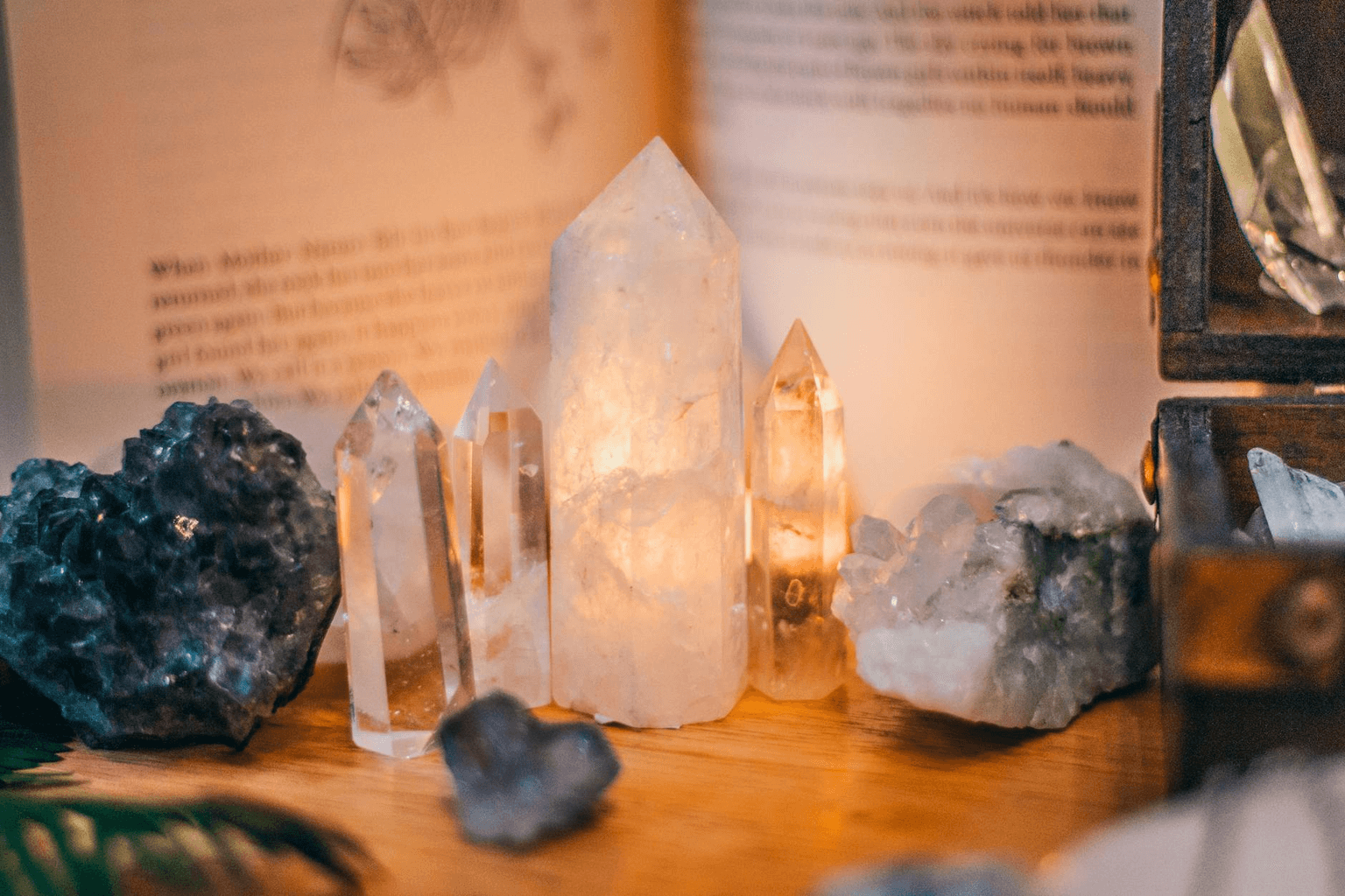 Amethyst and clear quartz crystals glowing in warm golden light on a wooden surface