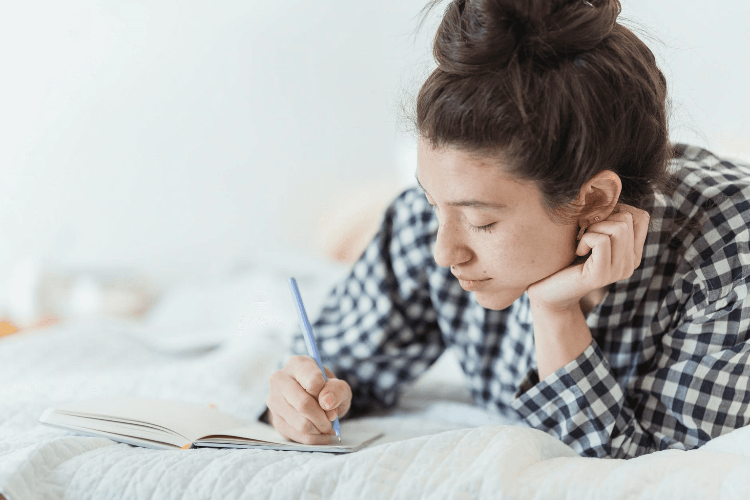 Person writing in a journal in warm morning light, engaged in intentional practice