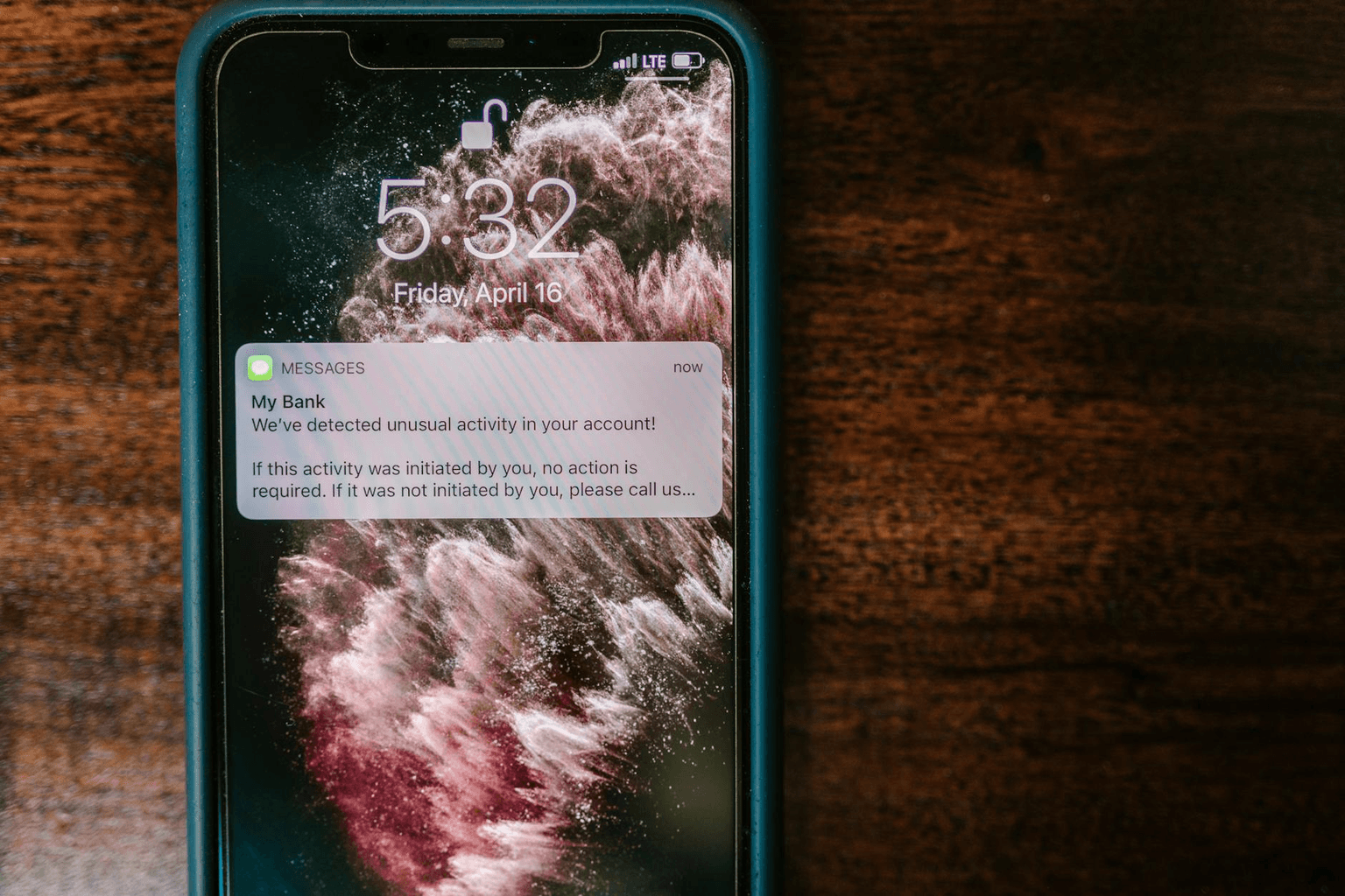 Person holding a smartphone with a new message notification in warm morning light
