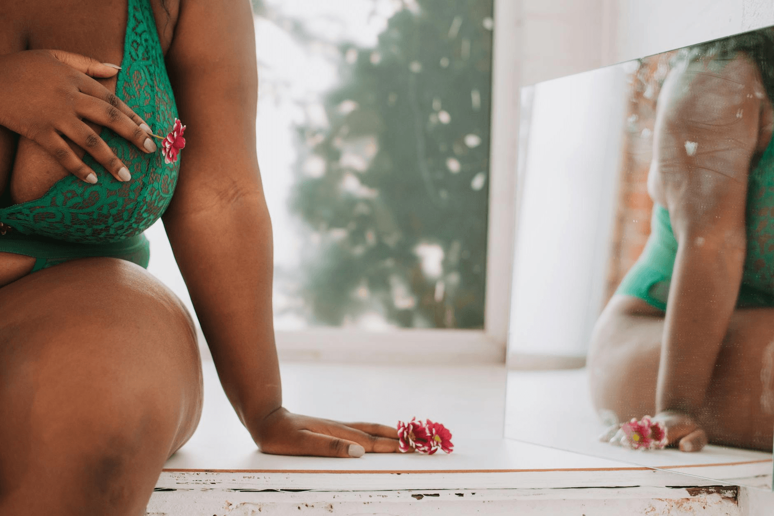 Woman with radiant confidence looking in a mirror in warm golden light