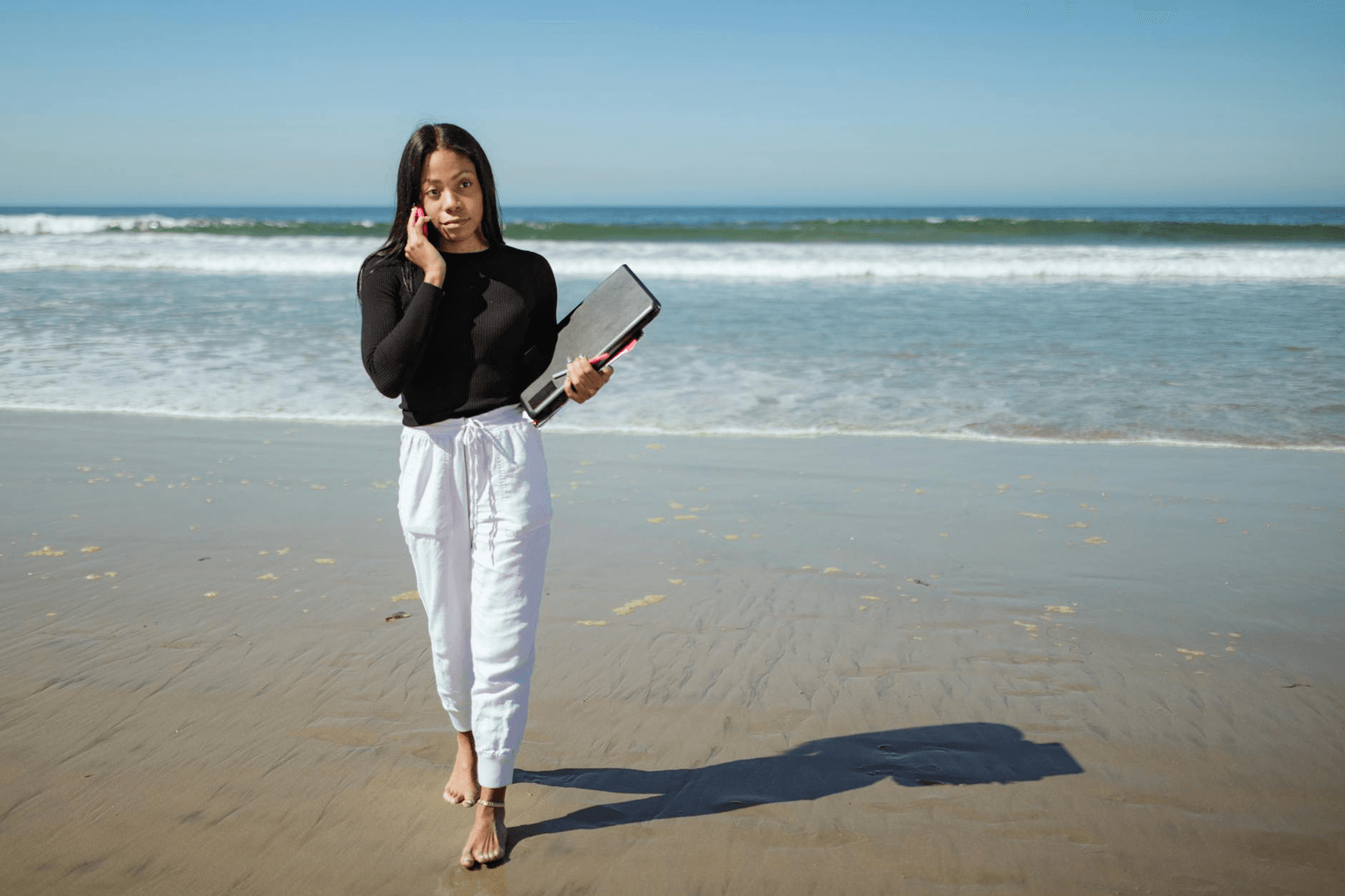 Person working on laptop at a beautiful outdoor location overlooking the ocean representing financial freedom and location independence