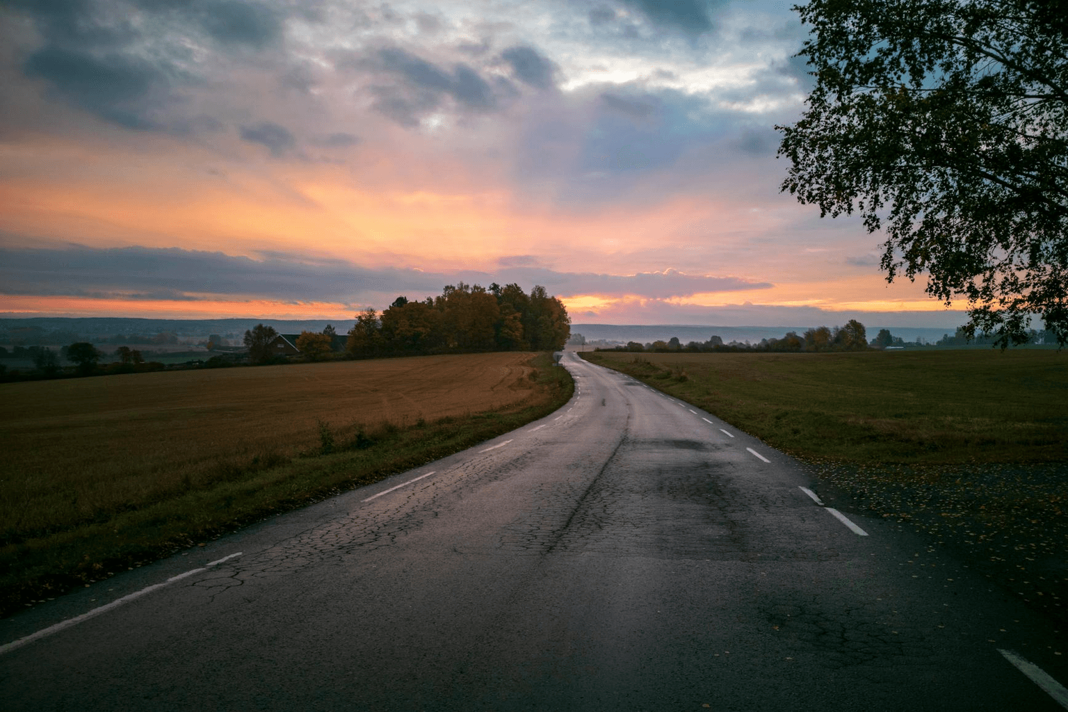 Open road stretching toward golden sunrise light, representing path toward manifestation